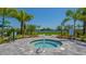 A serene spa area featuring a hot tub surrounded by landscaping and lush green grass for a relaxing getaway at 2309 Blue Mahoe Ln, Sarasota, FL 34240