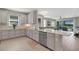 Modern kitchen featuring white cabinets, marble backsplash, stainless appliances and an open view of the living room at 3110 Tolmino Ct, Bradenton, FL 34211