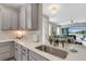 Kitchen with gray cabinets, and a view into the backyard with a pool and patio area at 3110 Tolmino Ct, Bradenton, FL 34211