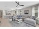 Bright living room with a large sectional sofa, white coffee table and open access to the kitchen at 3110 Tolmino Ct, Bradenton, FL 34211