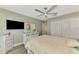 This main bedroom features a ceiling fan, TV, closet, and dresser with decorative elements for added charm at 320 Bermuda Ct, Venice, FL 34293