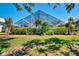 The screened pool offers privacy with surrounding bushes and landscaping in the backyard at 320 Bermuda Ct, Venice, FL 34293