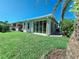 Back exterior view of the home with lush green lawn and sunroom at 321 Reclinata Cir, Venice, FL 34292