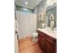 Cozy bathroom featuring a wood cabinet vanity, a shower with a curtain, and modern lighting at 321 Reclinata Cir, Venice, FL 34292