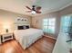 Comfortable bedroom featuring a ceiling fan, plantation shutters, and wood floors at 321 Reclinata Cir, Venice, FL 34292