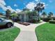 Community clubhouse surrounded by palm trees and lush landscaping at 321 Reclinata Cir, Venice, FL 34292