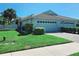 Charming single-story home with a well-manicured lawn, tile roof, and attached two-car garage at 321 Reclinata Cir, Venice, FL 34292