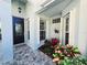 Covered front porch with decorative plants, tiled floor, and elegant front door at 321 Reclinata Cir, Venice, FL 34292