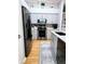 Well-lit kitchen features modern stainless steel appliances and gray cabinetry against a wood floor at 321 Reclinata Cir, Venice, FL 34292