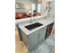 Kitchen with breakfast bar featuring modern countertops, undermount sink, stainless faucet, and contemporary gray cabinets at 321 Reclinata Cir, Venice, FL 34292