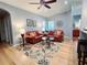 Inviting living room features two red couches, decorative rug and ceiling fan at 321 Reclinata Cir, Venice, FL 34292
