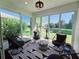Bright sunroom with modern chairs, patterned rug, and views of the lush backyard at 321 Reclinata Cir, Venice, FL 34292