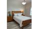 Bedroom with wood flooring featuring a wooden bed frame, two nightstands with lamps, and a window at 3702 54Th W Dr # 103, Bradenton, FL 34210