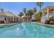 Large community pool with clear blue water, palm trees, lounge chairs, and a view of nearby buildings at 3702 54Th W Dr # 103, Bradenton, FL 34210