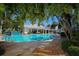 Inviting community pool area with a clubhouse, palm trees, lounge chairs, and lush tropical landscaping at 3702 54Th W Dr # 103, Bradenton, FL 34210