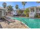 Exterior view of a community pool area with lounge chairs, lush landscaping, and multi-story building at 3702 54Th W Dr # 103, Bradenton, FL 34210