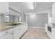 This kitchen featuring white cabinets and appliances offers a practical layout, open to the living space at 4027 Dyer Ln, Sarasota, FL 34232
