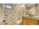 Charming bathroom featuring decorative palm tree wallpaper and a carved wooden vanity at 5055 Gulf Of Mexico Dr # 331, Longboat Key, FL 34228