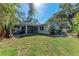 Beautiful backyard view featuring a covered patio with a well maintained lawn surrounded by tropical landscaping at 51 Webb St, Osprey, FL 34229