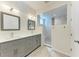 Bright bathroom featuring double sinks, sleek gray vanity, and luxurious walk-in shower with marble tile and seat at 51 Webb St, Osprey, FL 34229