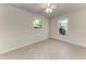 Minimalist bedroom featuring neutral walls, tile flooring, and natural light from windows at 51 Webb St, Osprey, FL 34229