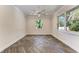 Bright bedroom with neutral walls, herringbone floors, ceiling fan, and two large windows at 51 Webb St, Osprey, FL 34229
