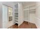 Open closet design featuring white shelves with hardwood flooring and bathroom access at 51 Webb St, Osprey, FL 34229
