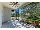 Charming screened-in porch with wood flooring, ceiling fan, and picturesque views of the front yard at 51 Webb St, Osprey, FL 34229