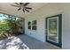 Inviting screened-in porch with tile flooring, a ceiling fan, and a decorative glass front door at 51 Webb St, Osprey, FL 34229