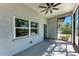 Relaxing screened-in porch with ample natural light, ceiling fan, and views of the front yard at 51 Webb St, Osprey, FL 34229