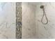 Luxurious shower featuring elegant marble tile with mosaic accent, rainfall shower head, and convenient built-in seat at 51 Webb St, Osprey, FL 34229