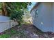 Picture of the side yard with a partial fence, landscaping, and access to the backyard at 51 Webb St, Osprey, FL 34229