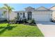Charming single-Gathering home featuring lush green grass, beautiful landscaping, and a two-car garage at 5277 Grove Mill Loop, Bradenton, FL 34211