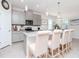 An open kitchen with modern gray cabinets, marble countertops, and seating at the island at 5277 Grove Mill Loop, Bradenton, FL 34211