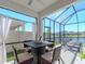 Screened-in patio features a tranquil water view, with dining and lounge areas, and an outdoor kitchen at 5277 Grove Mill Loop, Bradenton, FL 34211
