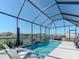 Screened-in pool and patio offer a serene water view, lounge chairs, and lush landscaping at 5277 Grove Mill Loop, Bradenton, FL 34211