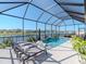 Screened-in pool and patio with lounge chairs offer a serene water view and lush landscaping at 5277 Grove Mill Loop, Bradenton, FL 34211