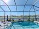 Screened-in pool with water feature offers a serene water view, with a seating area and sun loungers at 5277 Grove Mill Loop, Bradenton, FL 34211