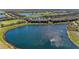 Panoramic aerial view showcasing the property, lake, and community golf course at 5577 Palmer Cir # 203, Bradenton, FL 34211