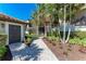 Landscaped walkway leading to the home's entrance, nestled amongst tropical plants at 5577 Palmer Cir # 203, Bradenton, FL 34211
