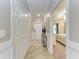 Bright hallway with closet doors and tiled flooring leads to bedroom with neutral decor and carpet at 5577 Palmer Cir # 203, Bradenton, FL 34211