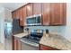 Kitchen with granite countertops, stainless steel appliances, and dark cabinets in a well-lit space at 5577 Palmer Cir # 203, Bradenton, FL 34211