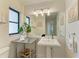Bright bathroom featuring a pedestal sink, decorative lighting, and accent art at 57 N Shore Dr, Anna Maria, FL 34216