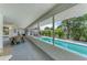 Screened-in porch with outdoor dining, overlooking pool and landscaped backyard at 57 N Shore Dr, Anna Maria, FL 34216