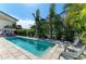 Backyard featuring a sparkling pool surrounded by lush landscaping and comfortable lounge seating at 57 N Shore Dr, Anna Maria, FL 34216
