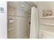 Tiled shower featuring shelving, a rainfall shower head, and mosaic accent tile at 57 N Shore Dr, Anna Maria, FL 34216