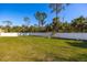Spacious backyard with lush green grass, a white fence, and a wooden playset at 5757 Jonesboro Ave, North Port, FL 34288