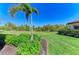 Lush backyard featuring a young palm tree and manicured landscaping on a sunny day at 5931 Wake Forest Run # 104, Bradenton, FL 34211