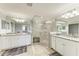 Spacious bathroom featuring dual sinks, granite countertops, and a glass-enclosed shower with bench seating at 5931 Wake Forest Run # 104, Bradenton, FL 34211