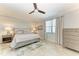 Serene bedroom with a ceiling fan, neutral decor, tile floors, and large windows for natural light at 5931 Wake Forest Run # 104, Bradenton, FL 34211